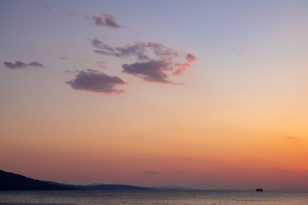 clouds appearing as the sky changes from blue to red at sunsetの写真素材