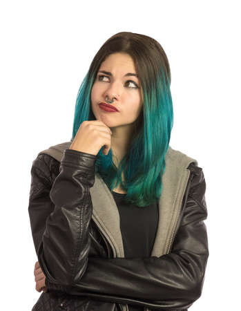 Beautiful girl looking upward with a lot of doubts on a white background. Pierced, turquoise haired and dressing a leather jacket.の写真素材