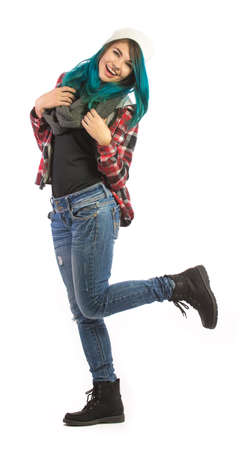 Beautiful smiling and happy girl on white background. Pierced, turquoise haired and dressing up a plaid jacket and blue jeans.の写真素材