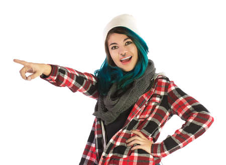 Beautiful smiling and amazed girl pointing forward on white background. Pierced, turquoise haired and dressing up a plaid shirt.の写真素材