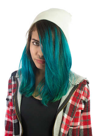 Beautiful hipster girl looking seriously at camera on white background. Pierced, turquoise haired and dressing up a plaid shirt.の写真素材