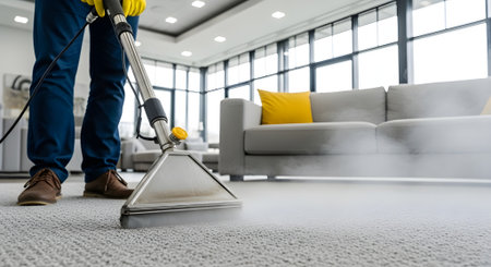 Cropped image of man cleaning carpet with vacuum cleaner in living roomの写真素材