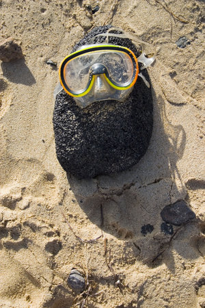 yellow diving glasses on the rockの写真素材
