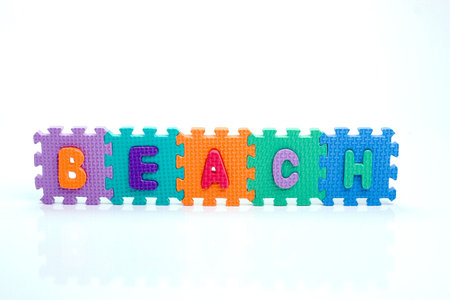 Colorful toy letters on spelling beach isolated in white backgroundの写真素材