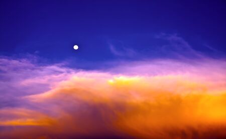 Beautiful blue sky and orange clouds with full moon  in twilight timeの写真素材