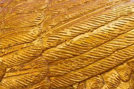 Craved golden bird feather pattern texture backgroundの写真素材