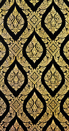Golden Thai pattern on black wall decoration in temple