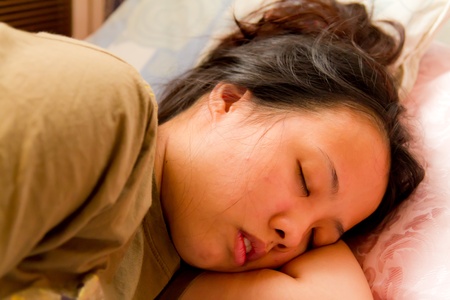 Asian woman closed her eyes and sleeping on bedの写真素材