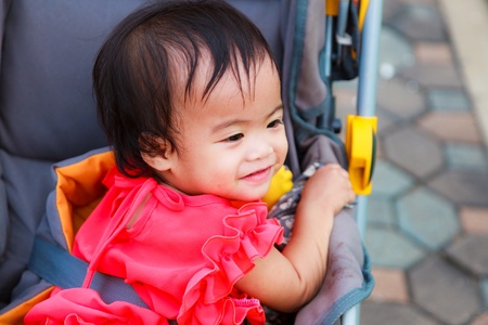 Asian female baby playing and smile in perambulatorの写真素材