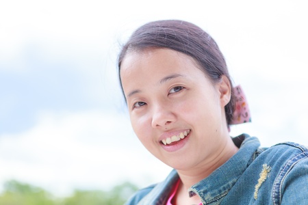 Asian woman in blue jeans shirt smilingの写真素材