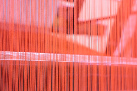Red silk thread in sewing or weaving machineの写真素材