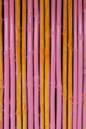 Seamless yellow pink bamboo stick striped pattern background texture surfaceの写真素材
