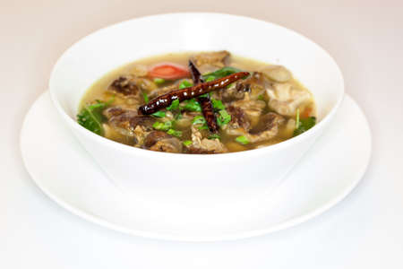 Thai style spicy pork soup in white bowl isolatedの写真素材