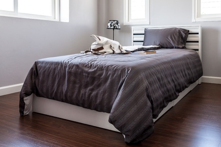 Bed with black sheet and pillow in white bedroomのeditorial素材