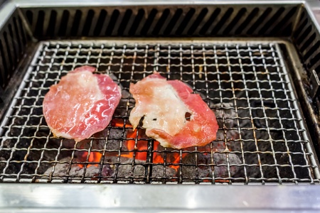 Grilling pork on fire with charcoalの写真素材