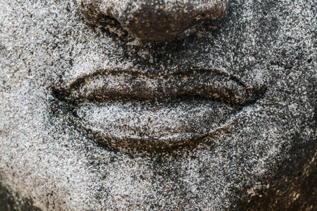Mouth of old and ancient buddha statue close upの写真素材