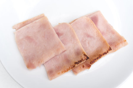 Sliced fried ham on white dish