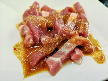 Sliced uncooked raw pork on white dishの写真素材