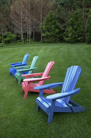 painted wood chairs on lawn in countryの写真素材