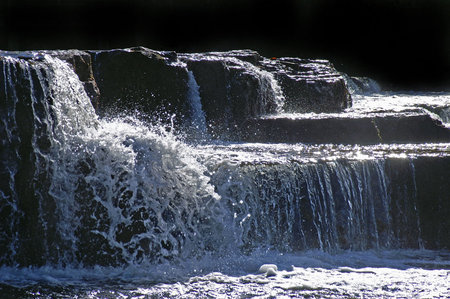 water falling over dark rocks