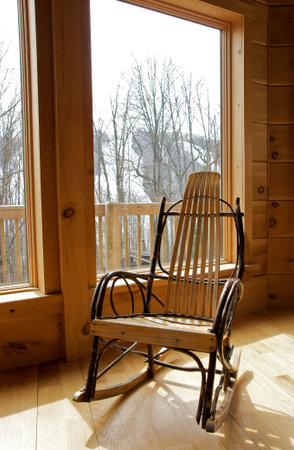 rustic wood rocking chair by windowの写真素材