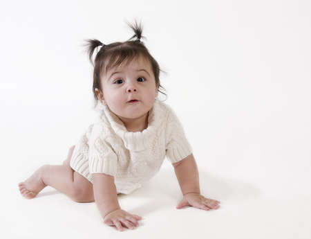 adorable baby girl in white dress crawlingの写真素材