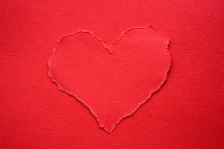 Red torn paper heart on red backgroundの写真素材