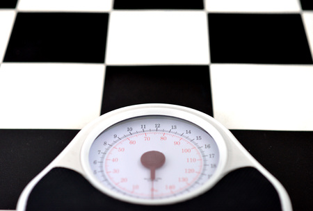 bathroom weighing scales and yellow striped socks on black and white flooringの写真素材