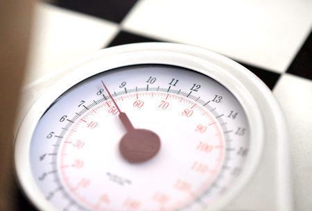 bathroom weighing scales on black and white flooringの写真素材