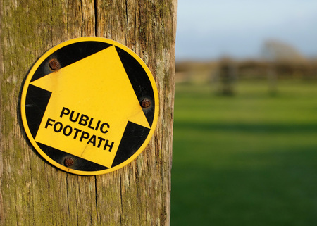 Yellow arrow on post showing public footpathの写真素材