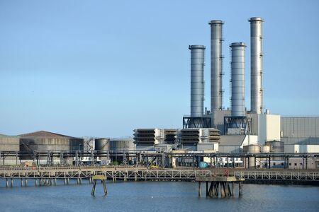 Chimneys of a power station next to a riverの写真素材