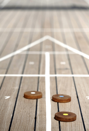 Shuffleboard game on the wooden deck of a cruise shipの写真素材