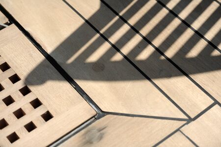 Shadow of deckchair cast on wooden deck of cruise shipの写真素材