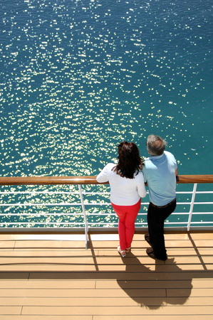 Man and woman on the deck of a cruise ship looking out to seaの写真素材