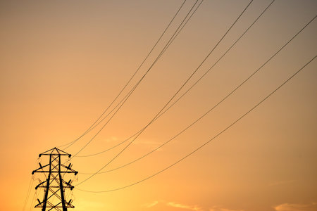 Electricity pylons at sunset, energy power lines