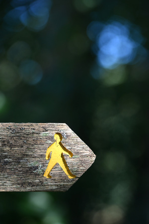 Yellow embossed walking man on footpath signの写真素材