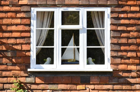 Wooden window in a tile hung wall on a houseの写真素材