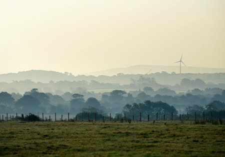 Morning mist at Ringmer, showing church and Glyndebourne wind turbine.の写真素材