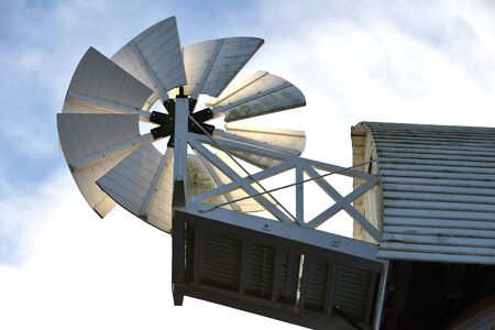 White wooden windmill in front of blue skyの写真素材