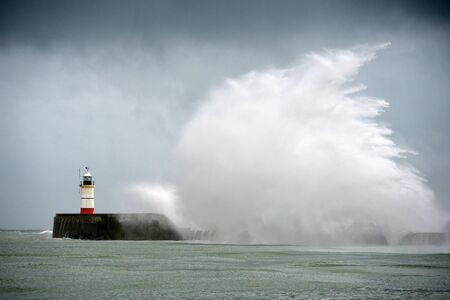 Large waves crashing over a breakwater during winter stormsの写真素材