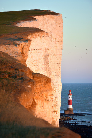 Lighthouse at Beachy Head with sheer chalk cliffsの写真素材