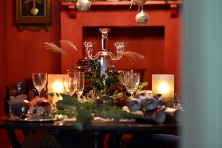 Christmas dining table fully dressed with decorations and foliage.の写真素材