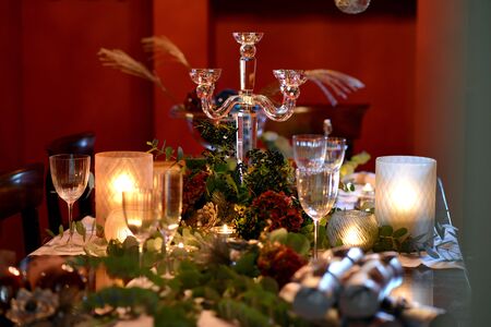 Christmas dining table fully dressed with decorations and foliage.の写真素材