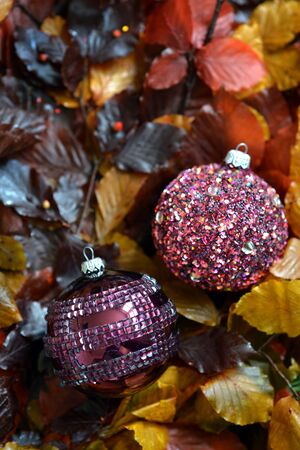 Traditional Christmas glass baubles on colorful leaves.の写真素材