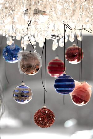 Traditional Christmas glass baubles hanging from a chandelierの写真素材