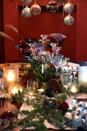 Christmas dining table fully dressed with decorations and foliage.の写真素材