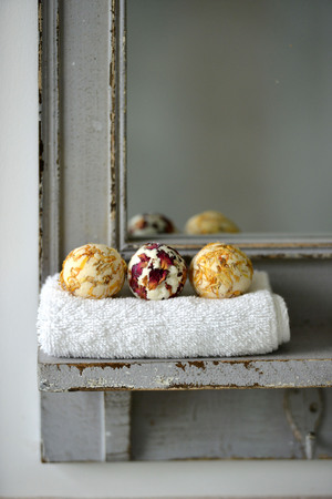 Round colourful bath bombs with flower petals in a bathroomの写真素材