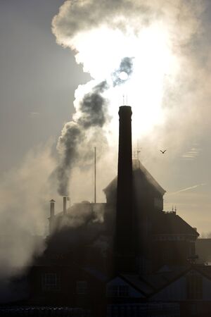 Steam rising from an old brewery chimney stackの写真素材