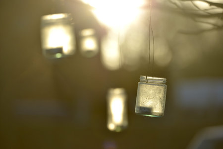 Jar lanterns handing from a tree in winter