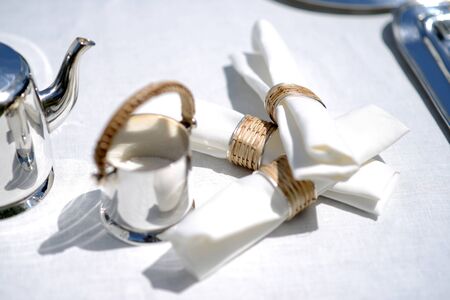 White linen napkins in silver and wicker napkin ringsの写真素材